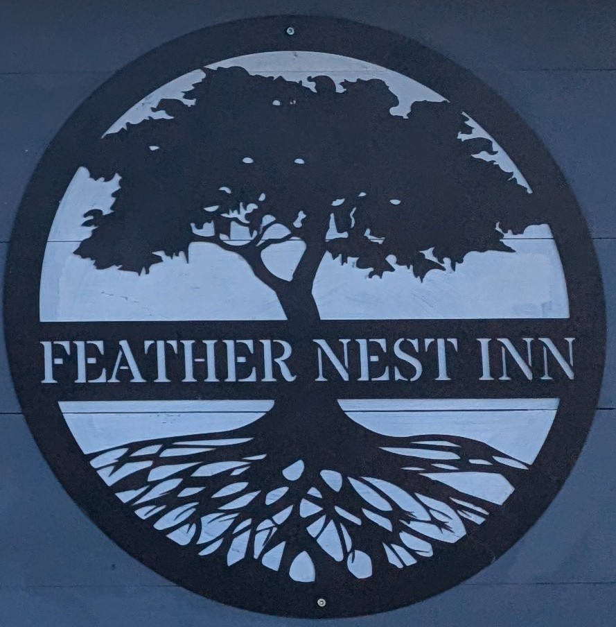 Feather nest inn logo- a circle with tree with large root system