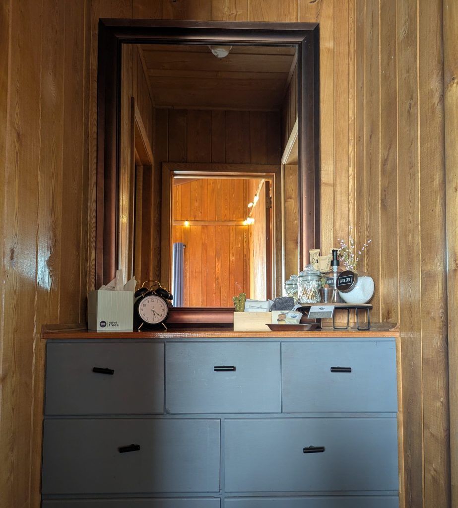 Built in dresser with guest amenities and a large mirror