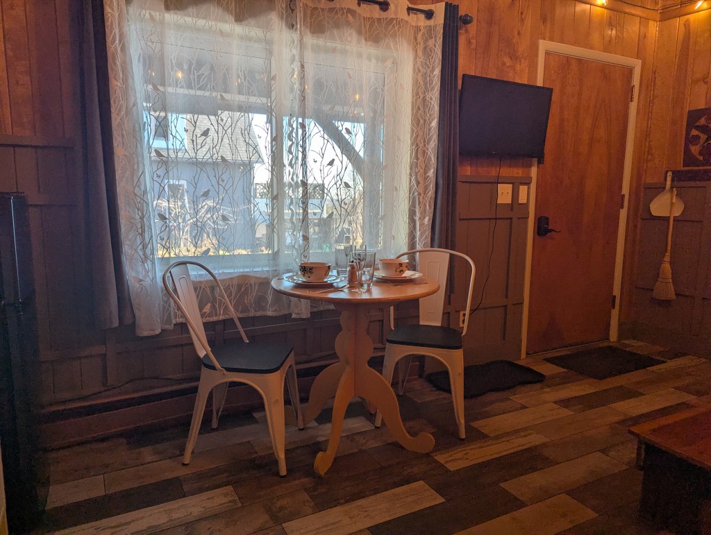 set dining table next to a window and TV mounted