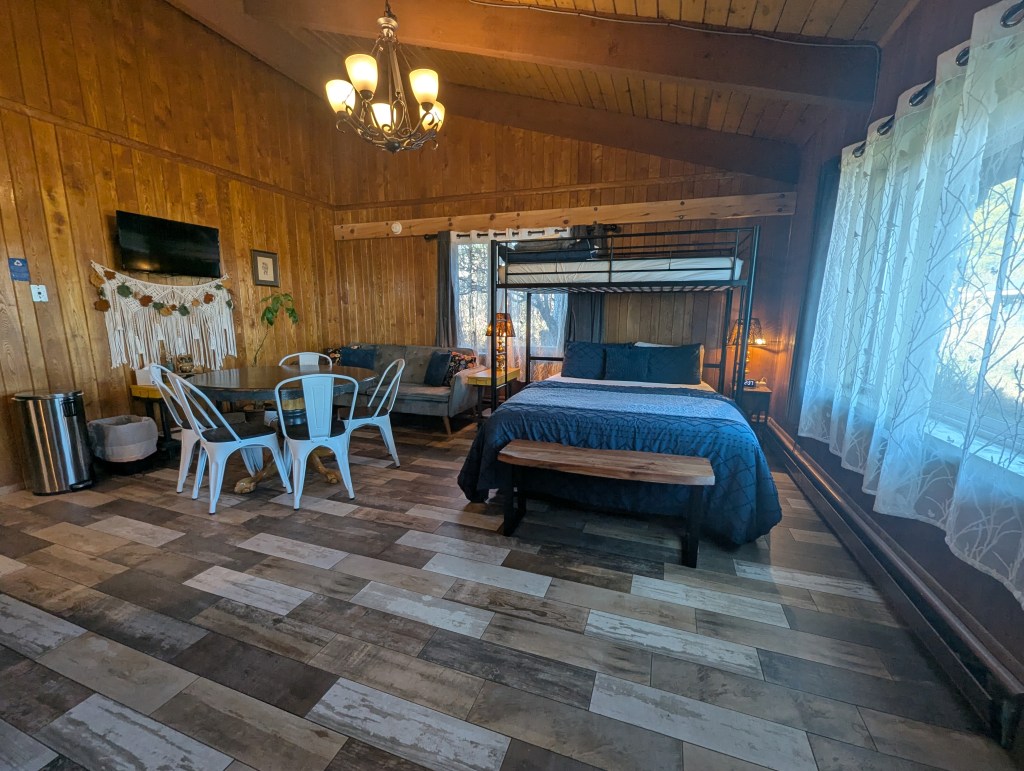 living area with couch, dining table, and bed with loft bed