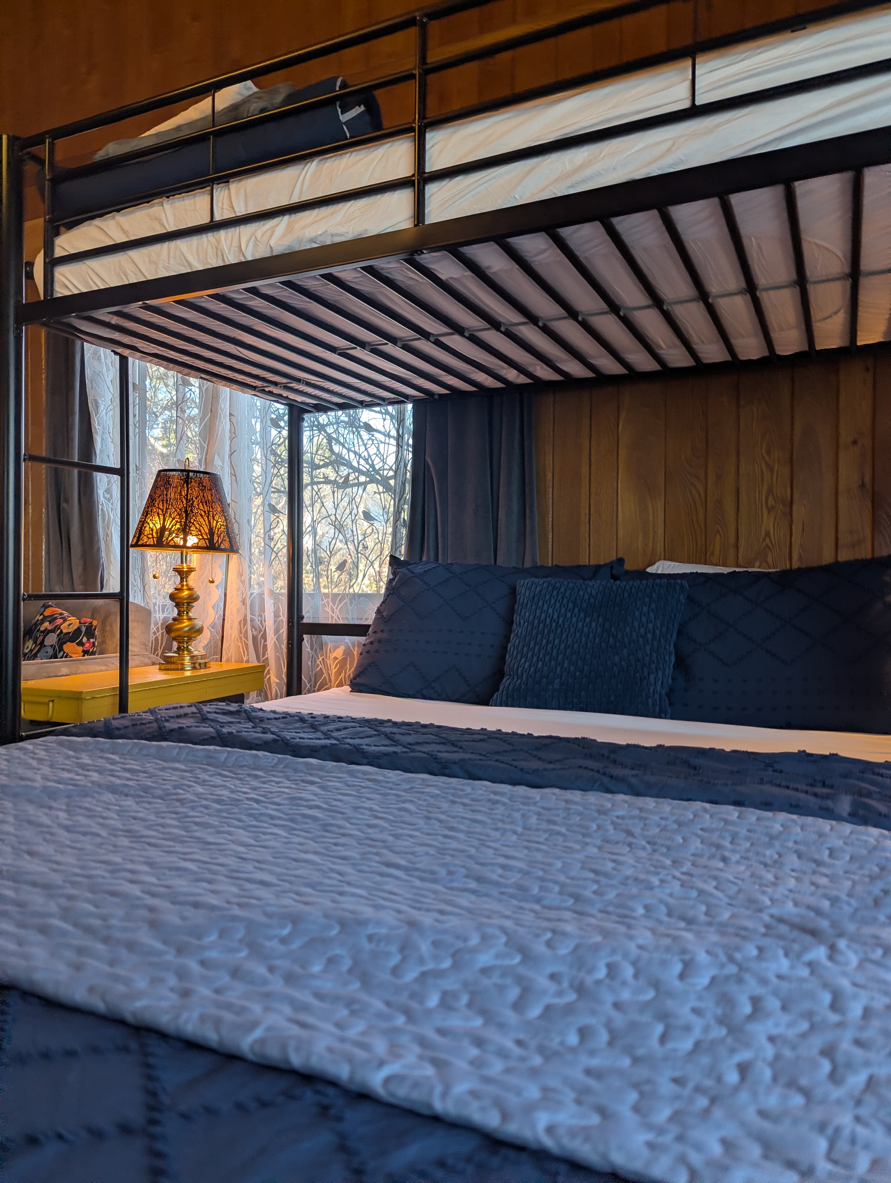 close up of bunk style bed with side table and lamp